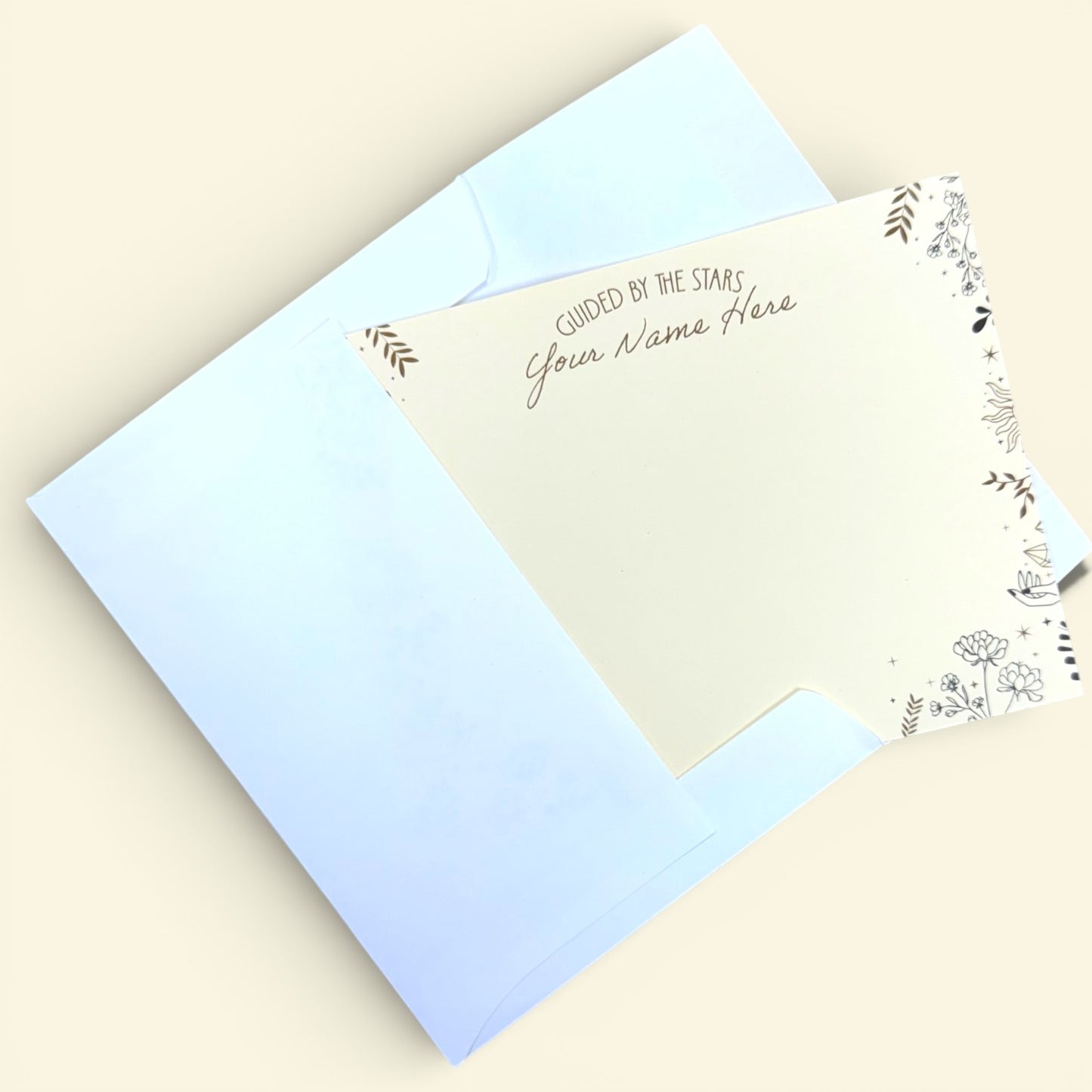 Set of 10 cream A2 notecards with personalized gold foil text and celestial floral border, paired with light blue envelopes.