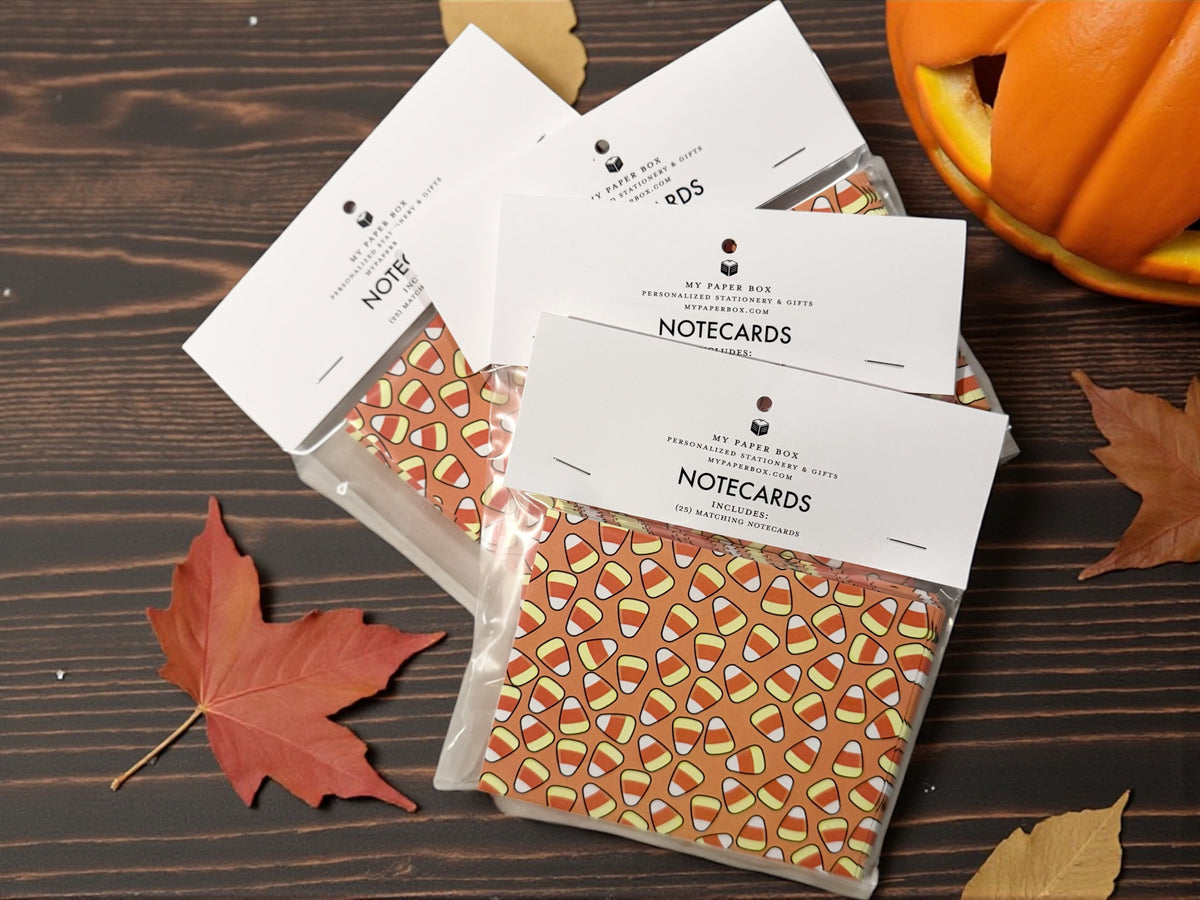 Custom stationery set of personalized candy corn patterned notecards with white envelopes on wooden surface. - Candy Corn Notecard Set