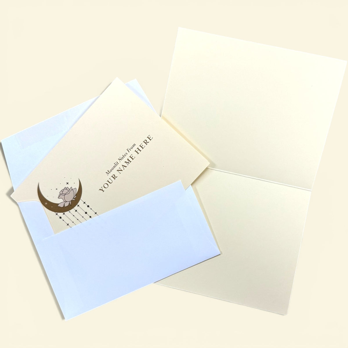 Set of 10 cream folded cards with crescent moon design and "You're Here" text, paired with pale blue envelopes and blank.