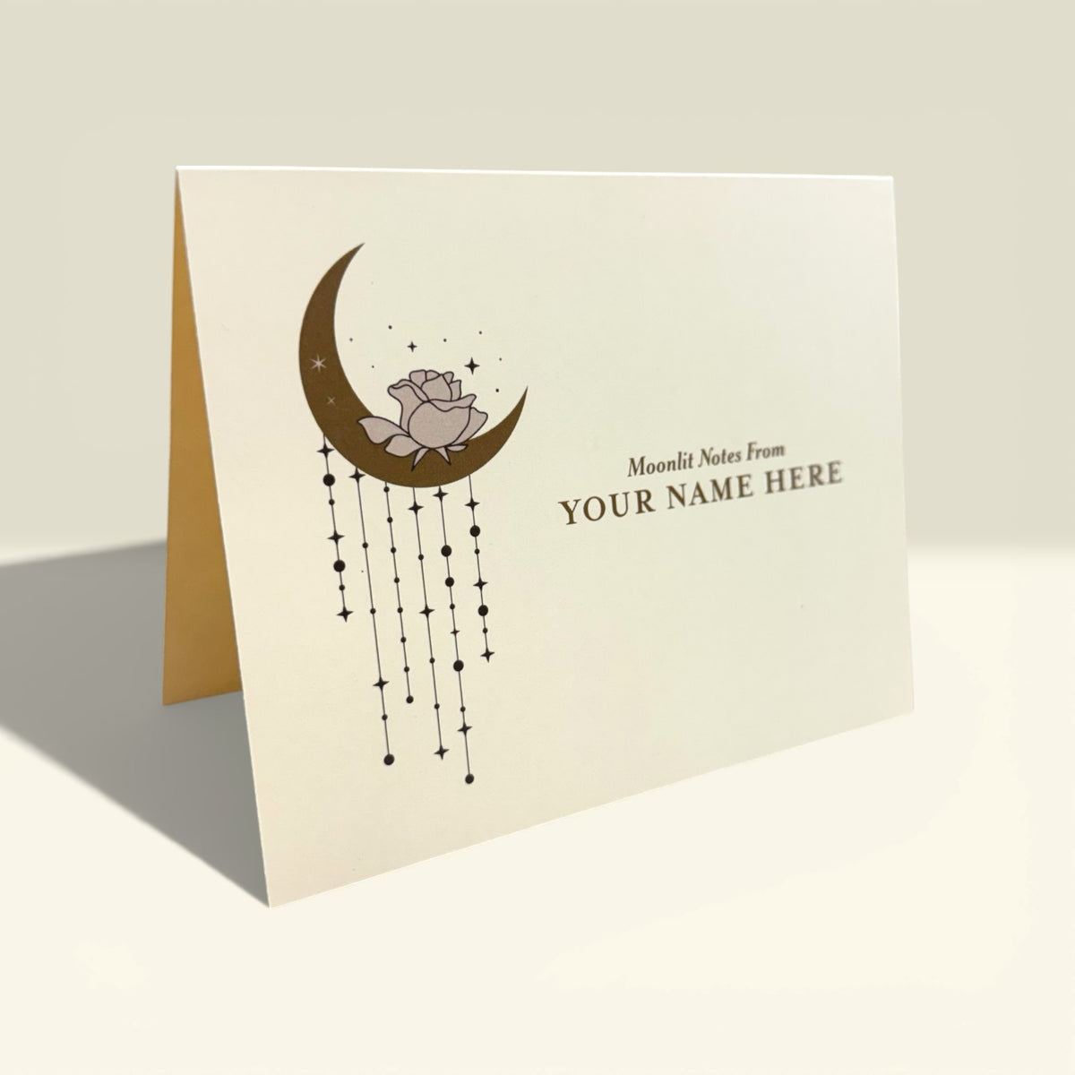 Cream folded card featuring a brown crescent moon with hanging stars and a cute bear, customizable name text.