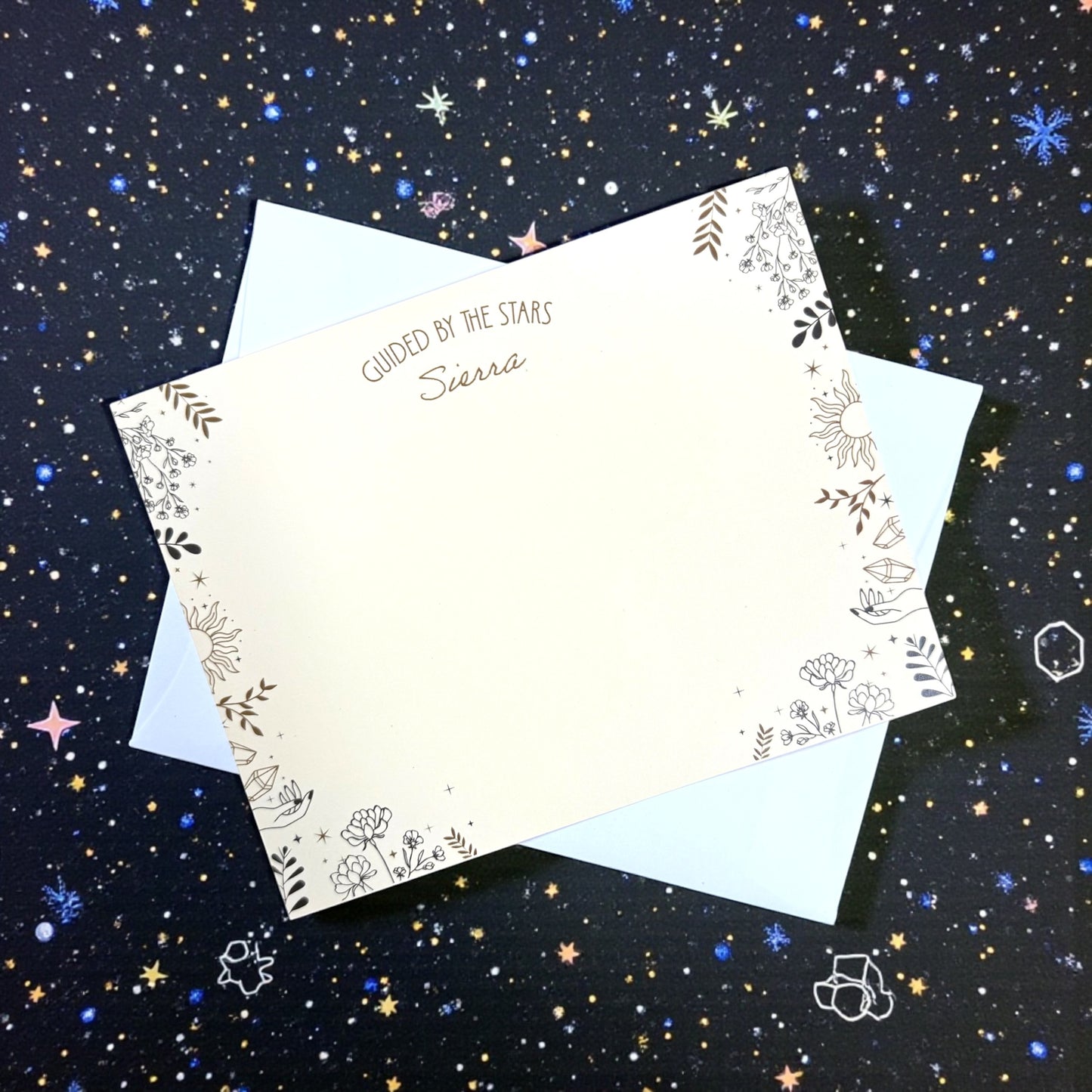 A2 flat notecard with personalized name, gold celestial border, and light blue envelope on starry background.