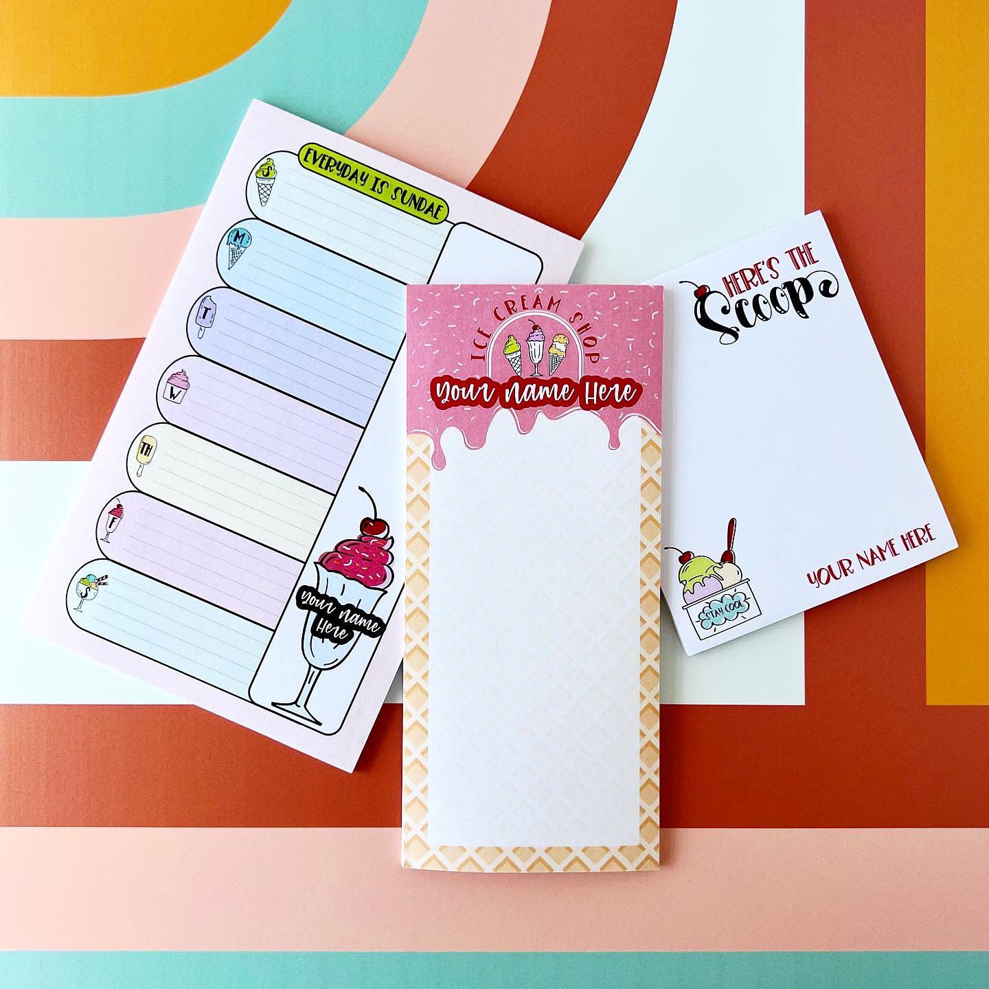 Set of personalized notepads with ice cream-themed designs on a colorful striped background