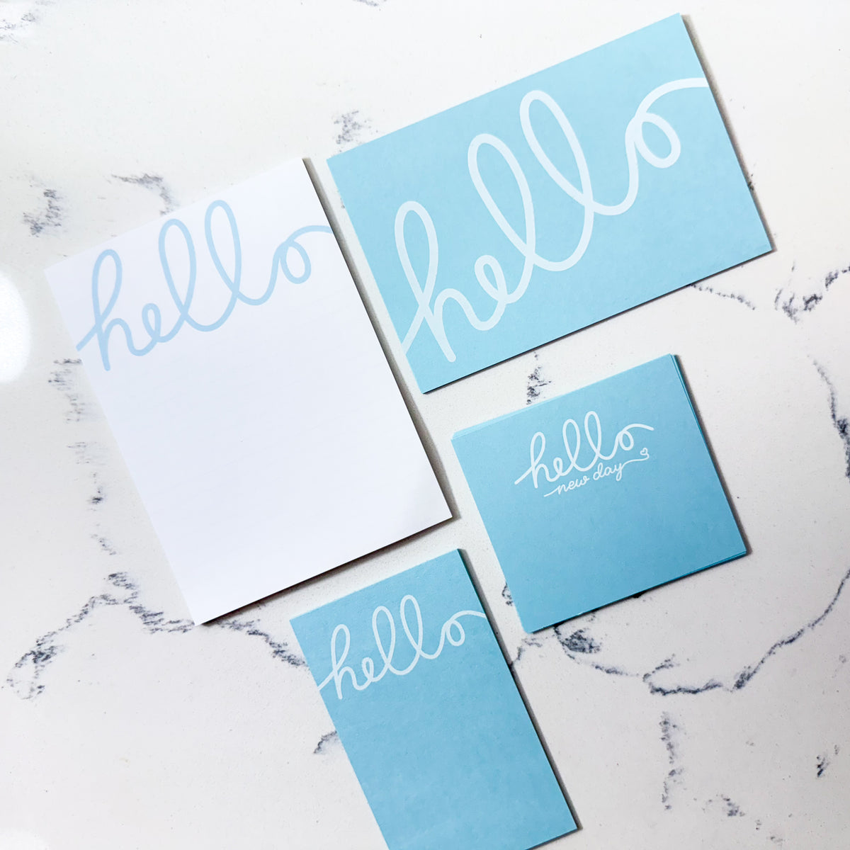 Minimal blue stationery set featuring personalized "hello" notecards and matching notepad on marble surface. - Hello Stationery Gift Set | Minimal Blue Notecards & Notepad