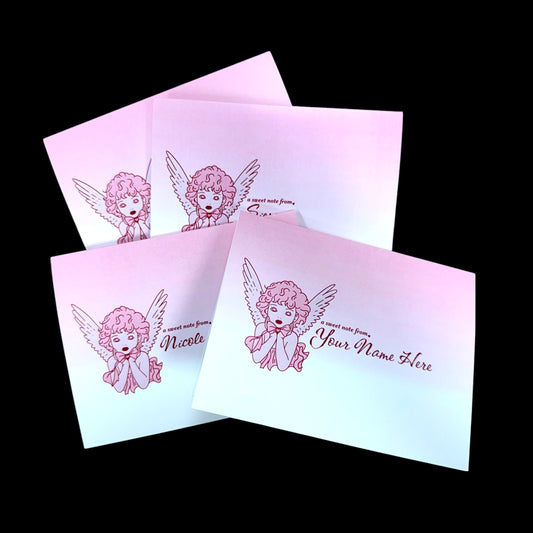 Set of four pink angel note cards with folded design and customizable name text on front.