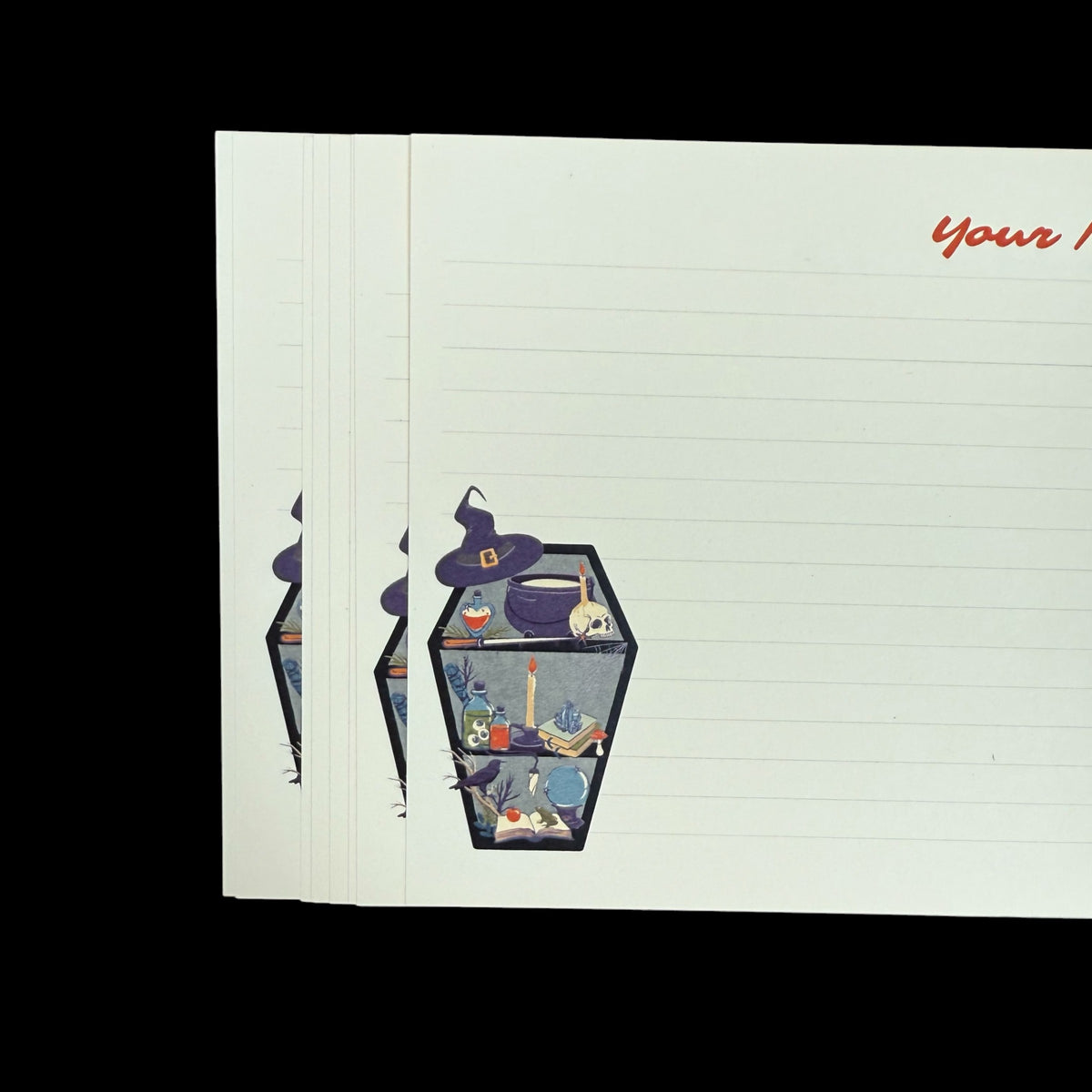 Set of lined notecards featuring a small colorful witchy coffin illustration in the corner with potion bottles and candles.