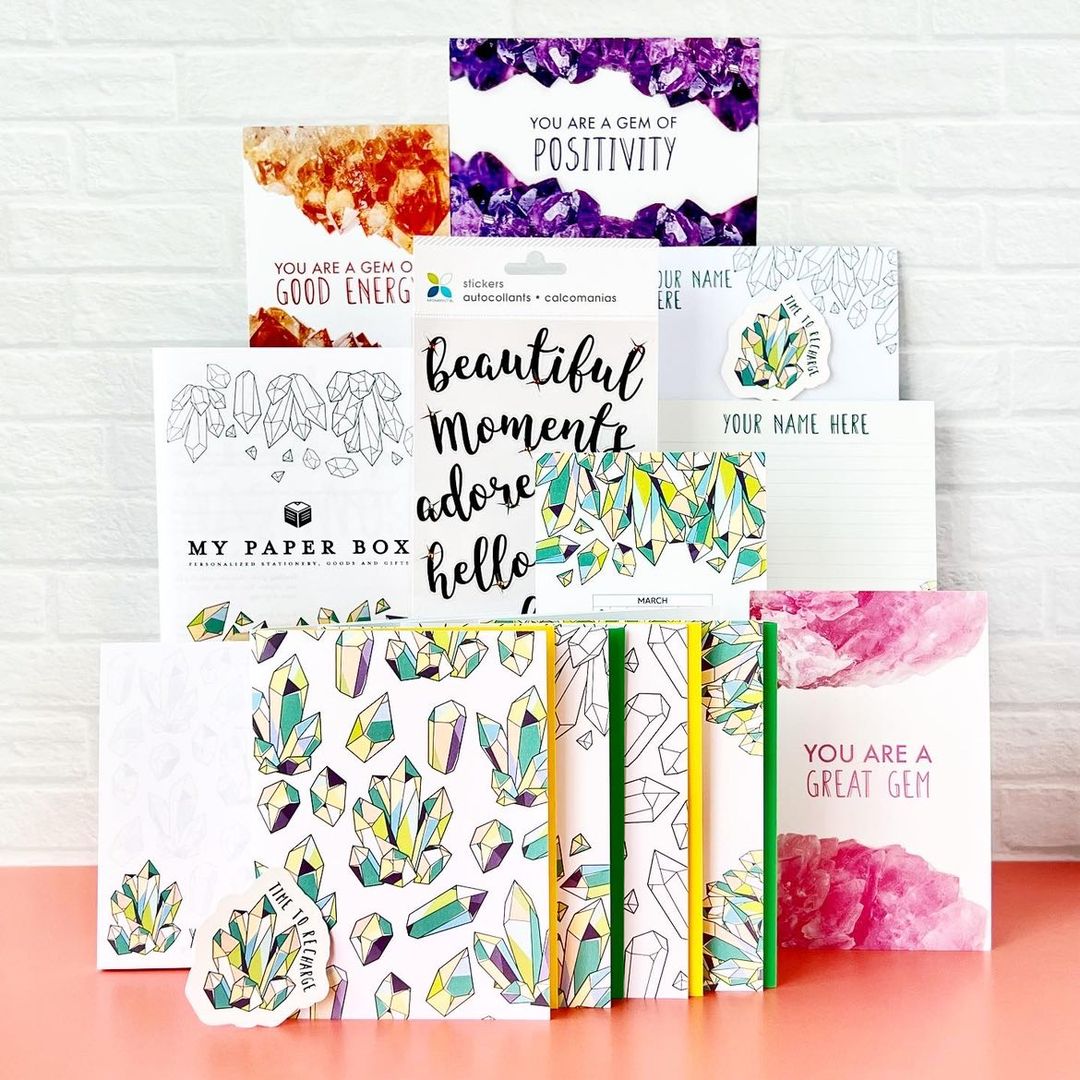 Collection of colorful greeting cards with crystal designs and motivational phrases on a white background.