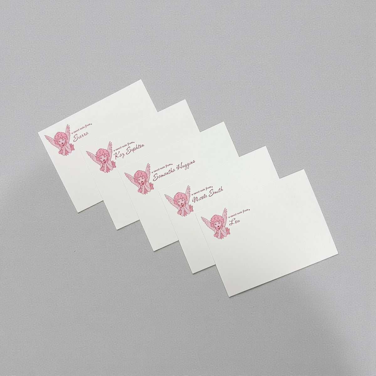 Set of five white notecards with pink angel illustration and "From the desk of" text.