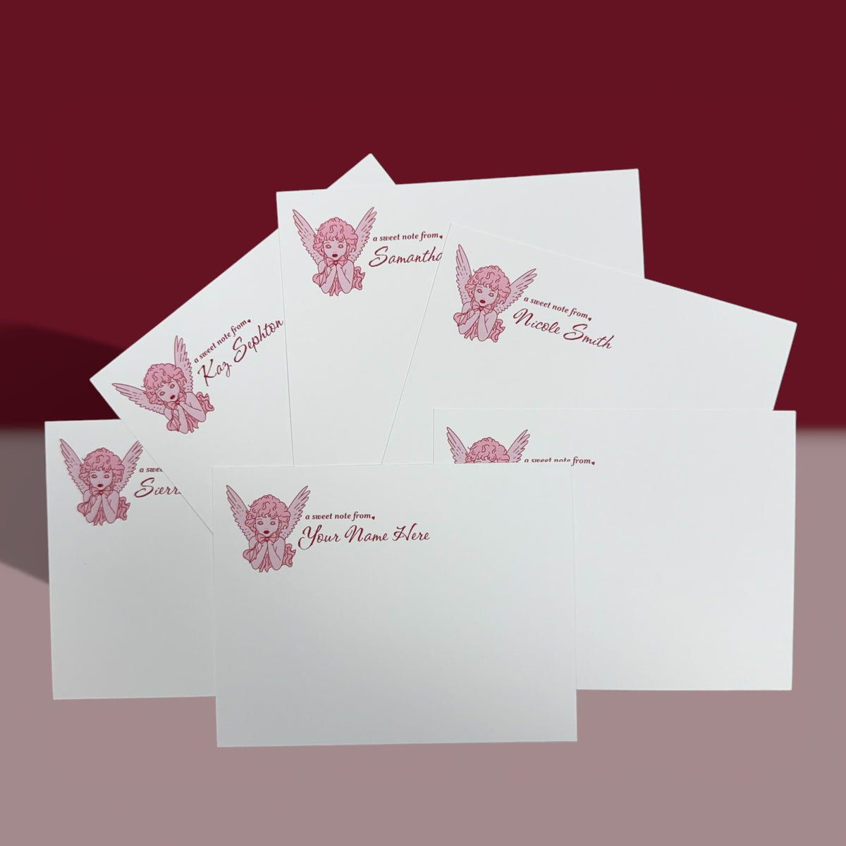 Set of white personalized stationery cards with pink angel graphic and custom text at the top.