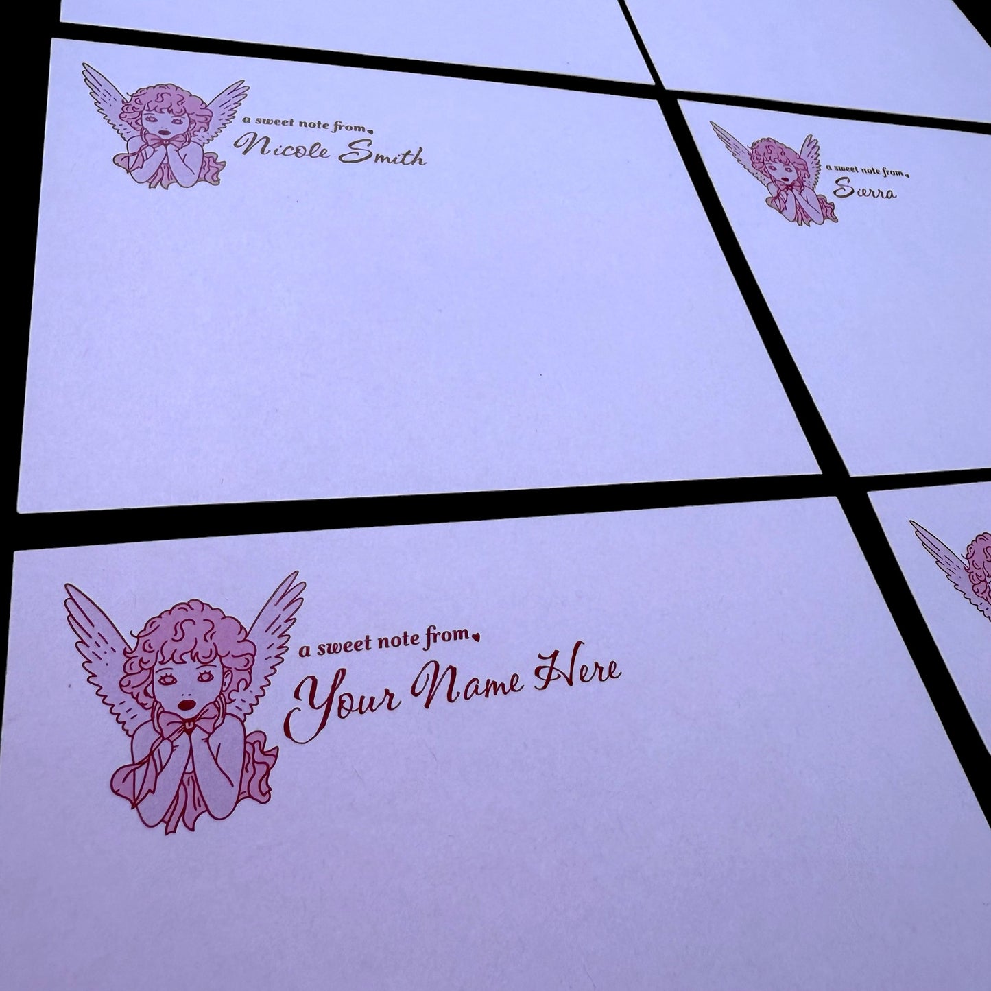 Personalized stationery with angel design and customizable text on a light purple background.