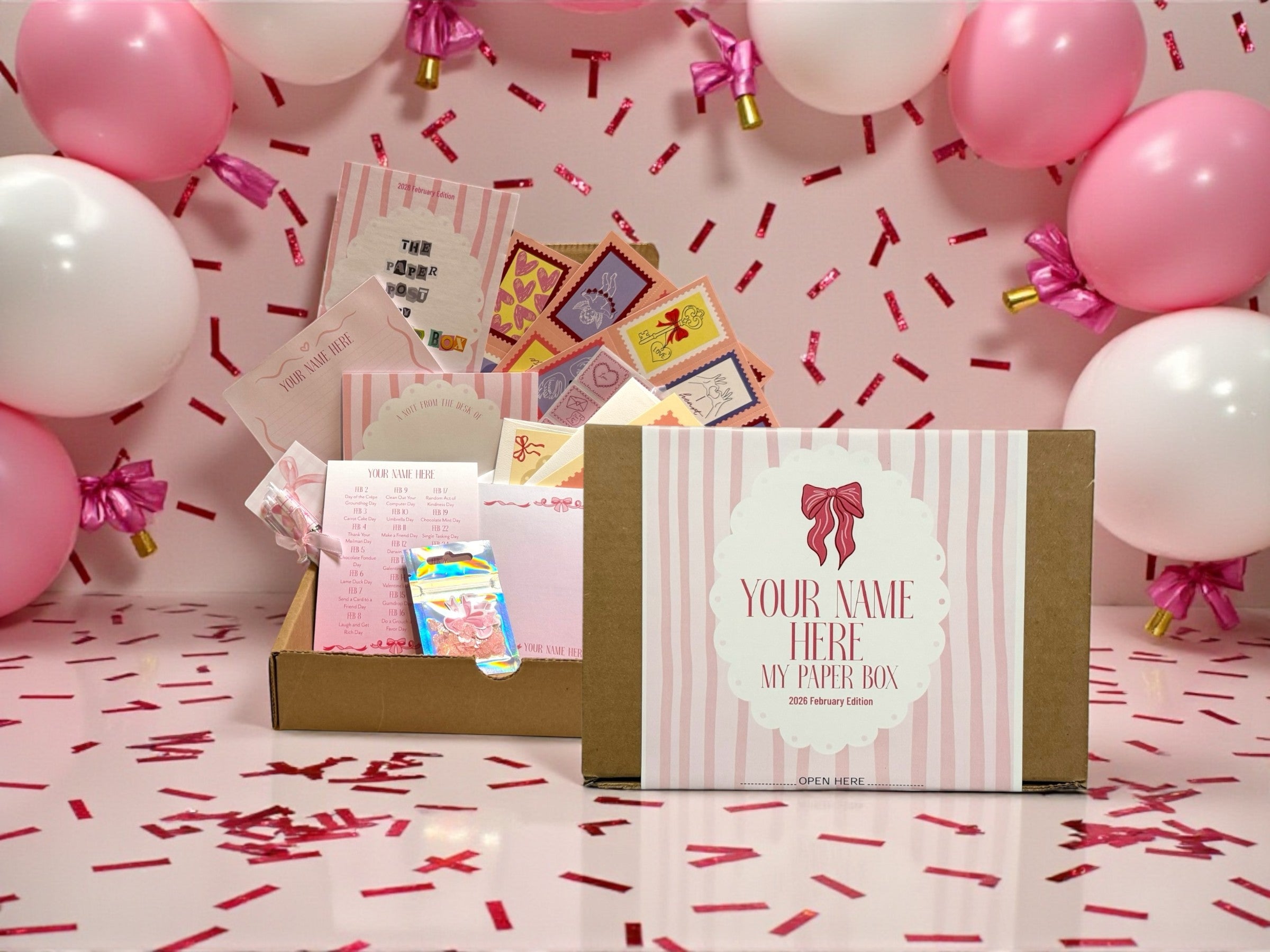 Personalized paper box with stationery items on a pink and white balloon background
